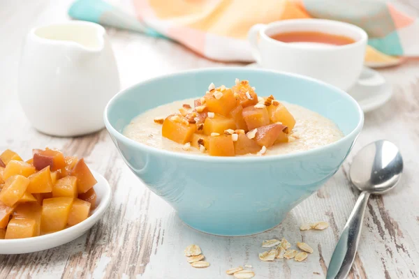 Harina de avena con melocotones caramelizados, té y yogur — Foto de Stock