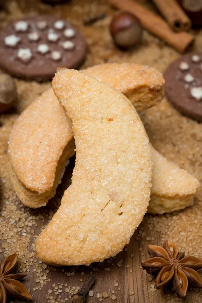 Сахарное печенье, специи и орехи на деревянном фоне — стоковое фото