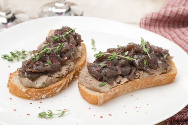 Pain grillé avec pâté de foie, oignon rouge caramélisé et thym en gros plan — Photo