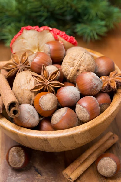 Cuenco de madera con nueces y especias, primer plano —  Fotos de Stock