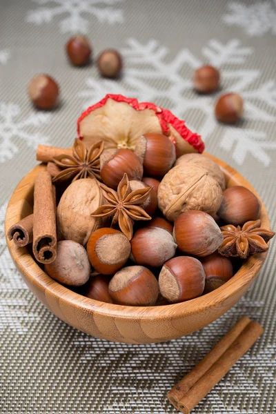 Houten kom met noten en specerijen — Stockfoto