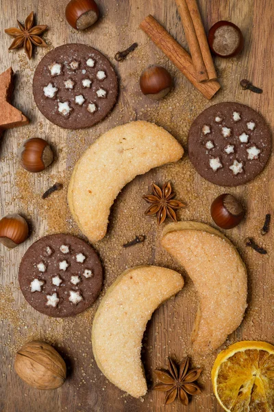 Weihnachtsplätzchen, Gewürze und Nüsse auf Holzgrund — Stockfoto