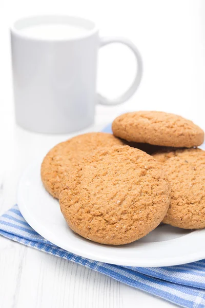 Oatmeal cookies on a plate and cup of milk — Stock Photo, Image