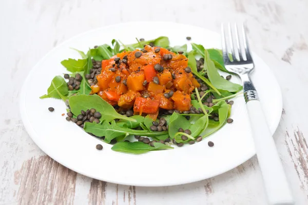 Tallrik sallad med ruccola, svarta linser och grönsaksgryta — Stockfoto