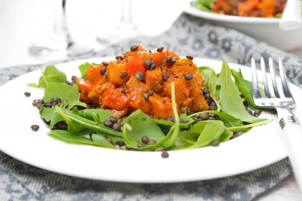 Salad with arugula, black lentils, vegetable stew in tomato sauce — Stock Photo, Image