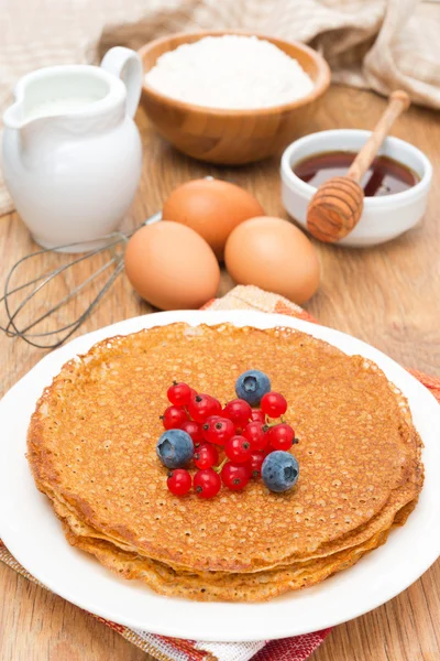 Crepes with berries and ingredients for baking — Stock Photo, Image