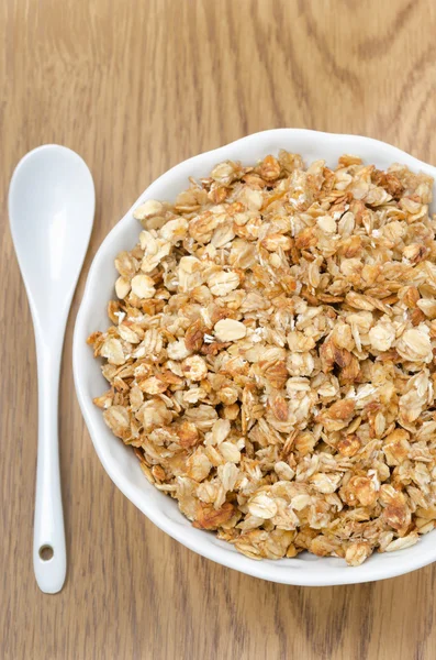 Zelfgemaakte muesli in een kom en lepel close-up bovenaanzicht — Stockfoto