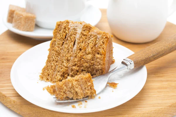 Stück Honigkuchen auf einem Teller und Gabel auf Holzbrett — Stockfoto