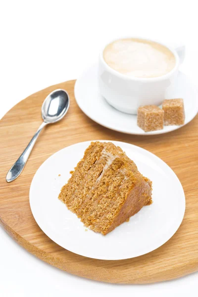 Stuk van honing cake en een kopje cappuccino op houten bord — Stockfoto