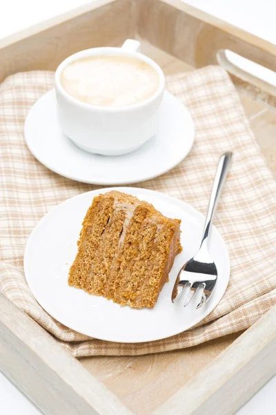 Pedazo de pastel de miel y taza de capuchino en una bandeja de madera —  Fotos de Stock