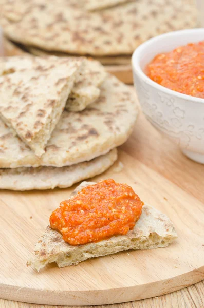 Roasted pepper dip with almonds, garlic on a piece of bread — Stock Photo, Image