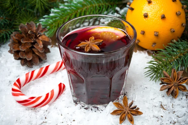 Baharatlı mulled şarap cam üzerinde kar ve karamelli şeker — Stok fotoğraf