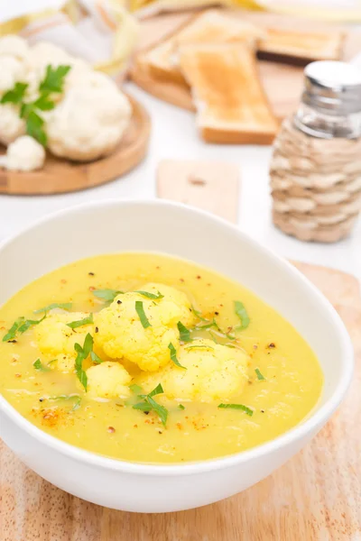 Суп из цветной капусты с карри в белой миске — стоковое фото