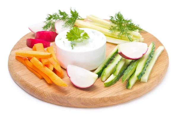 Sauce with feta cheese and assorted vegetables on a wooden board — Stock Photo, Image