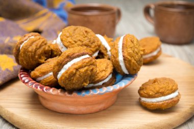 Balkabağı çerezleri bir ahşap tahta üzerinde dolgu krema ile kase