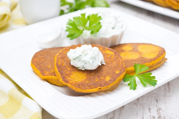 Pumpkin pancakes with feta cheese sauce and greens — Stock Photo, Image