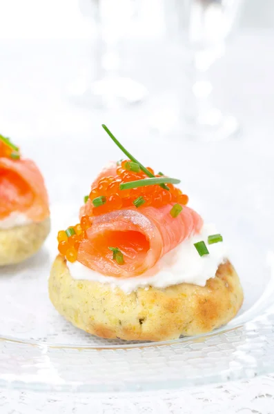 Appetizer - potato bun with salted salmon, red caviar and chives — Stock Photo, Image