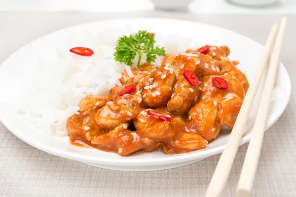 Filé de frango em molho de tomate com sementes de gergelim, pimenta e arroz — Fotografia de Stock