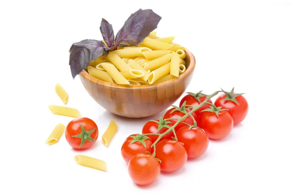 Makaron penne, świeżymi pomidorami i bazylią na białym tle — Zdjęcie stockowe