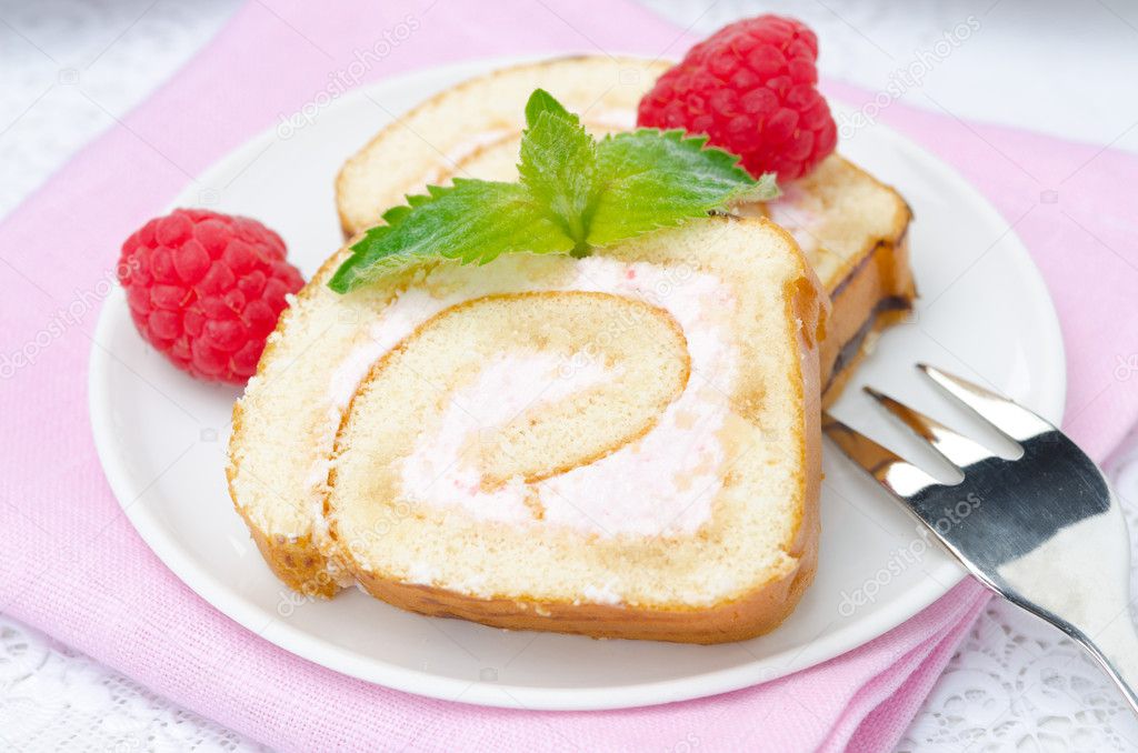 piece of swiss roll with raspberry cream on a plate