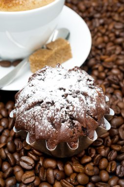 Çikolatalı kek ve cappuccino kahve çekirdekleri üzerine kahverengi şeker