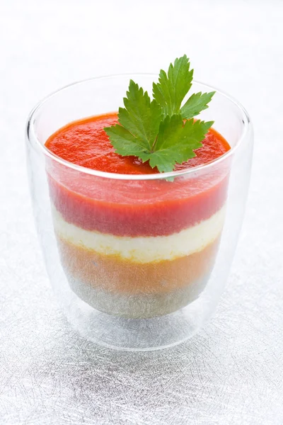 amuse van geprakte gekleurde paprika's met geitenkaas in een glas