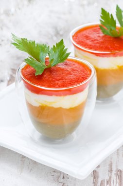 amuse van geprakte gekleurde paprika's met geitenkaas in een glas