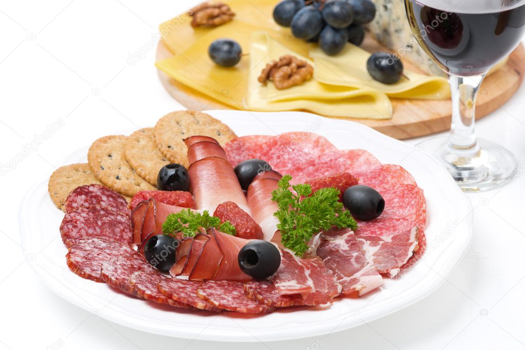 Assorted deli meats, plate of cheese and glass of wine closeup