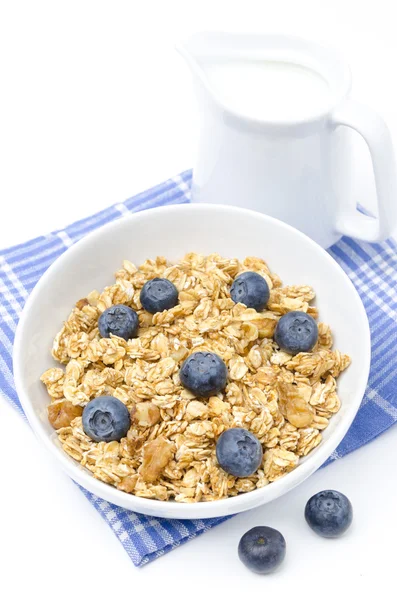 Muesli with blueberries and jug of milk isolated on white — Stock Photo, Image