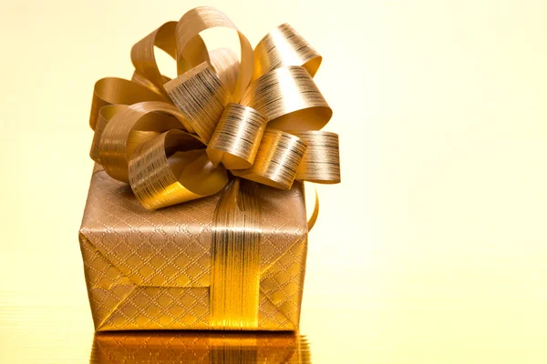Karácsonyi ajándék doboz egy arany háttér, közelről — Stock Fotó