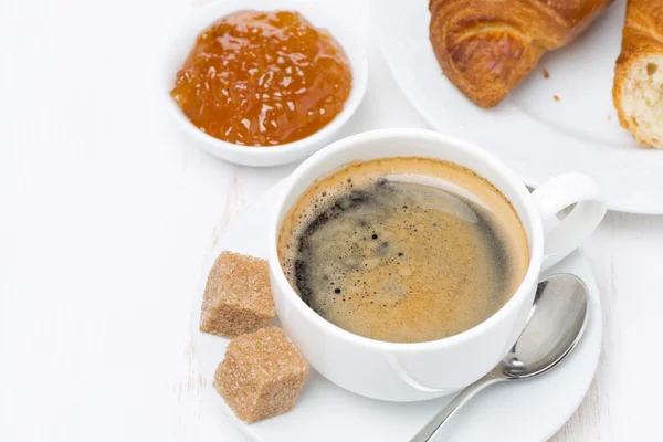 Morgenmad med sort kaffe, croissanter og orange marmelade, topudsigt - Stock-foto