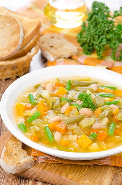 Vegetable minestrone with white beans and toast vertical — Stock Photo, Image