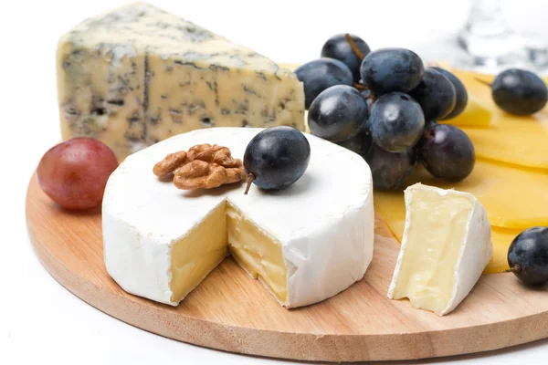 Assorted cheeses and grapes on a wooden board, isolated — Stock Photo, Image