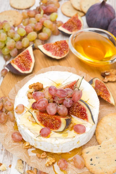 Camembert with grapes, figs, honey, crackers and walnuts — Stock Photo, Image