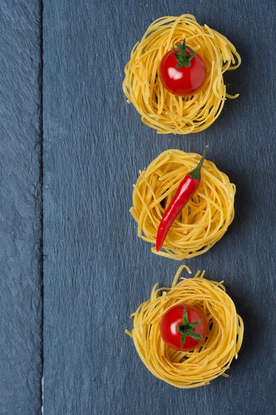 Italian egg pasta nest with cherry tomatoes and chili, concept