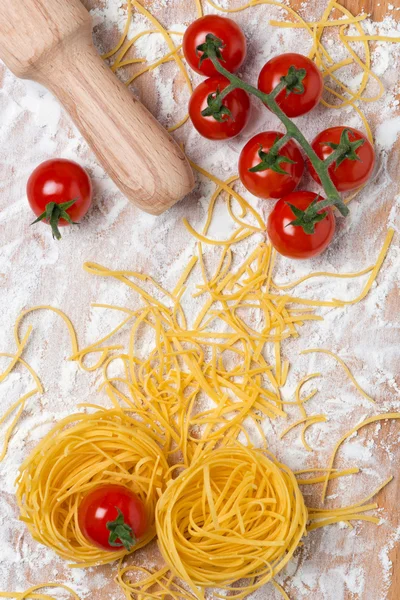 Italiaanse pasta nest eieren, cherry tomaten en deegroller — Stockfoto