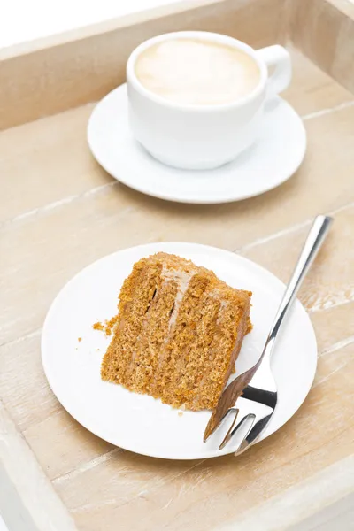 Stück Honigkuchen und eine Tasse Cappuccino auf einem Holzblech — Stockfoto