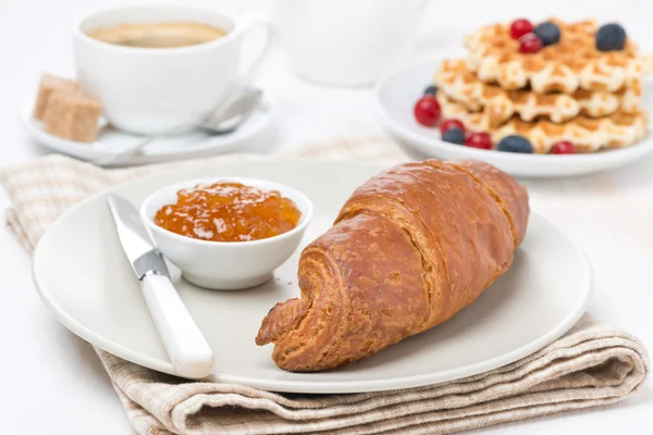 Сладкий завтрак с круассаном, джемом, вафлями, ягодами и кофе — стоковое фото