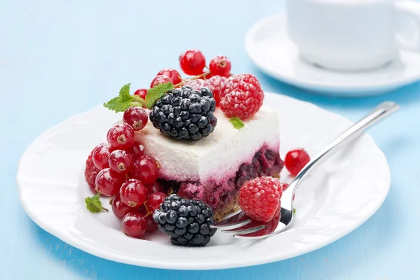 Dessert - a piece of cake with fresh berries on blue background — Stock Photo, Image
