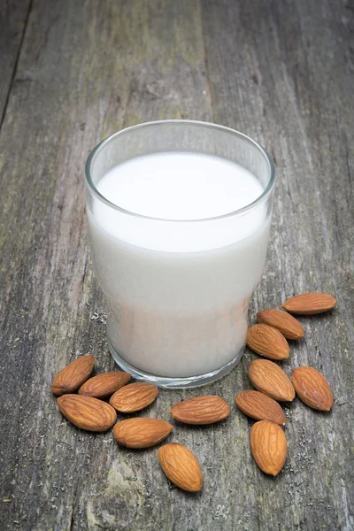 Glass of almond milk on a wooden table — Stock Photo, Image