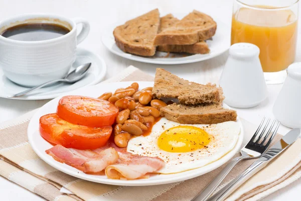 Traditional English breakfast with fried eggs, bacon and beans