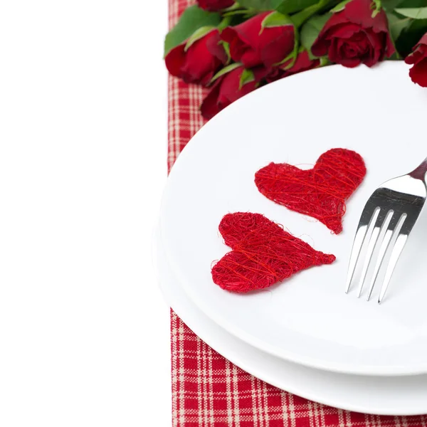 Dos corazones de mimbre en un plato y rosas rojas, aisladas — Foto de Stock