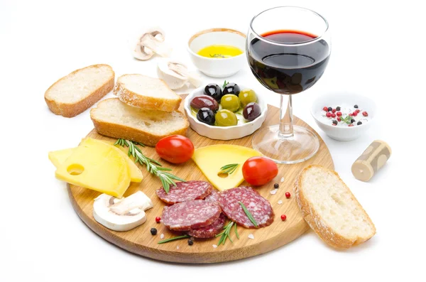 Salami, kaas, brood, olijven, tomaten en glas rode wijn — Stockfoto