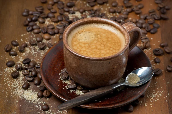 Kopje espresso, suiker en koffie bonen op houten tafel — Stockfoto