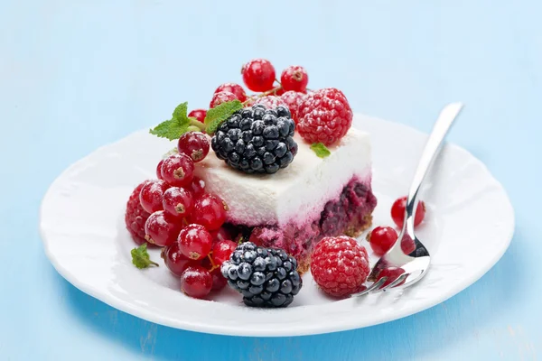 Шматок чізкейку зі свіжими ягодами на тарілці — стокове фото