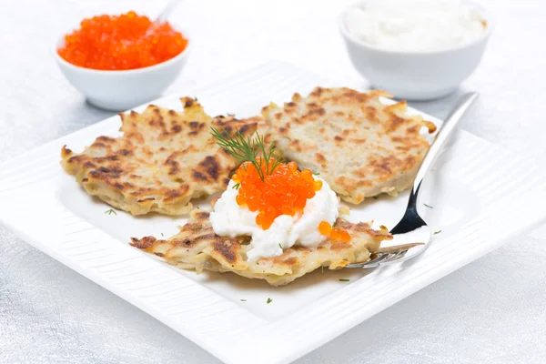 Potato pancakes with red caviar and sour cream on the plate — Stock Photo, Image