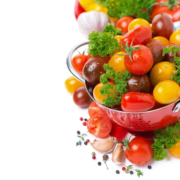 Tomates cereja variados em um escorredor, temperos e ervas frescas — Fotografia de Stock