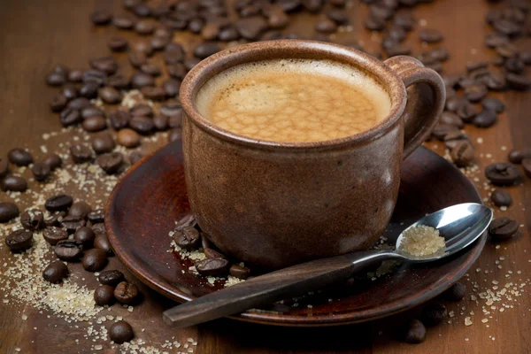 Чашка эсперсо, сахар и кофейные зёрна на деревянном столе — стоковое фото