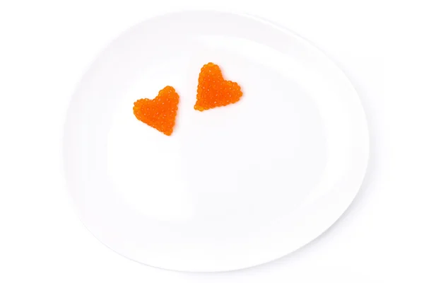 Dos corazones de caviar rojo en un plato, aislado —  Fotos de Stock
