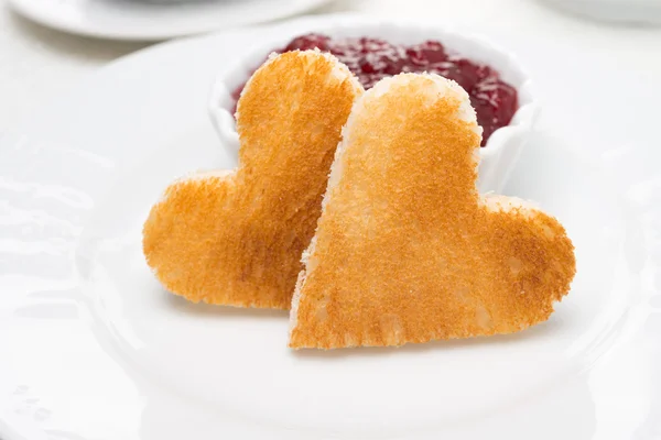 Two toast bread in the shape of hearts and berry jam, close-up — Stock Photo, Image